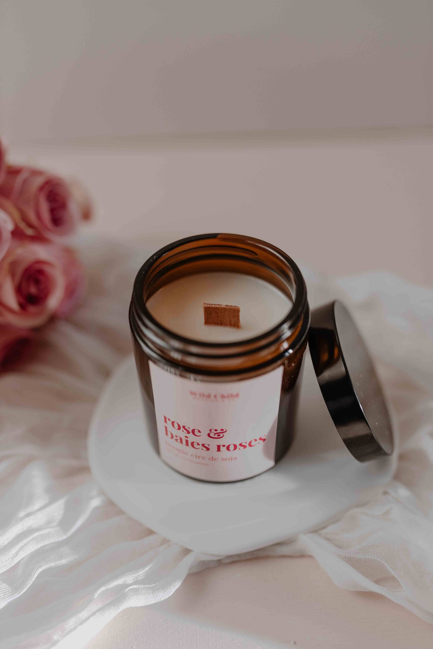 bougie rose pink berries allumée avec mèche bois crépitante dans un intérieur élégant