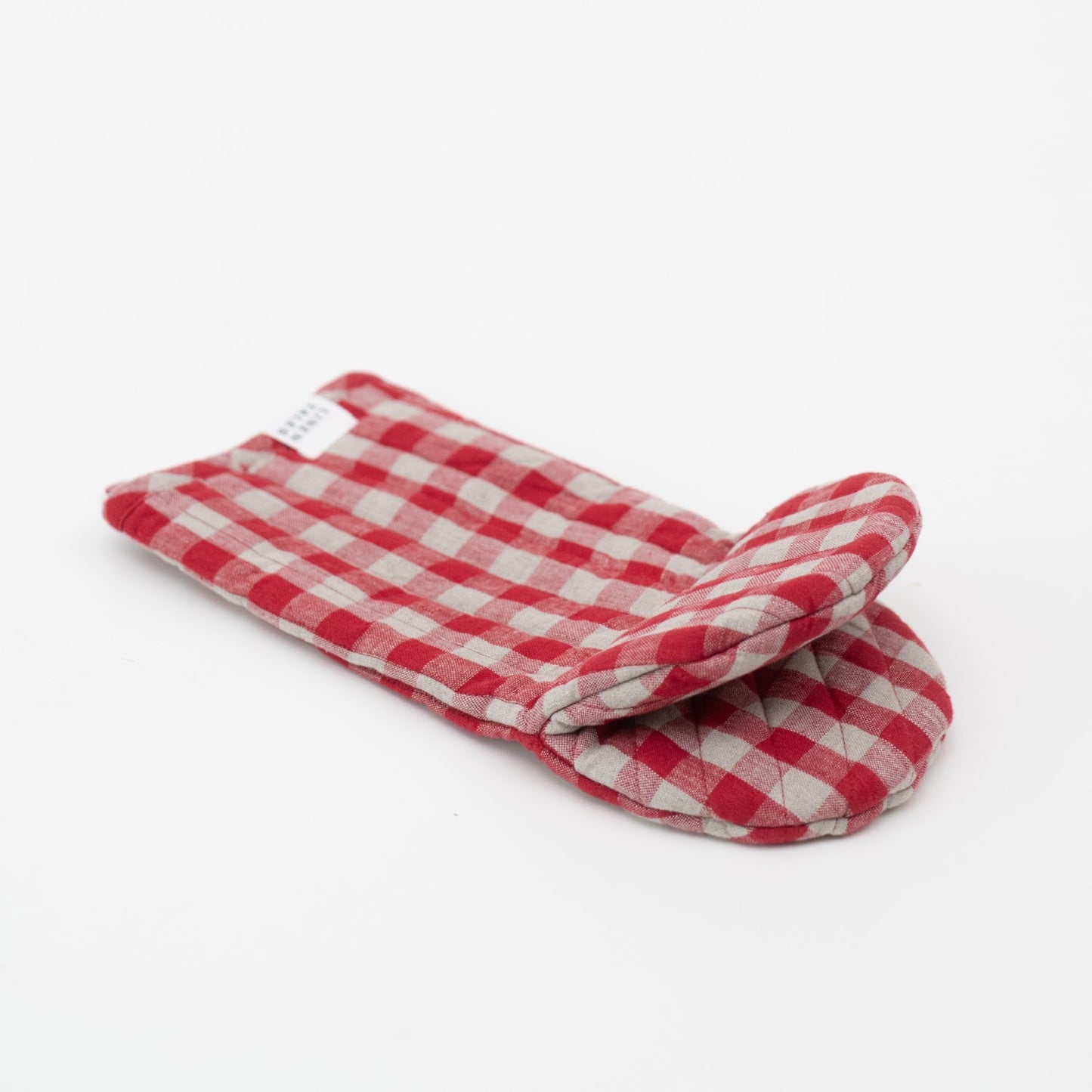 Zoom sur la matière en lin lavé à carreaux rouges, finition artisanale et texture douce