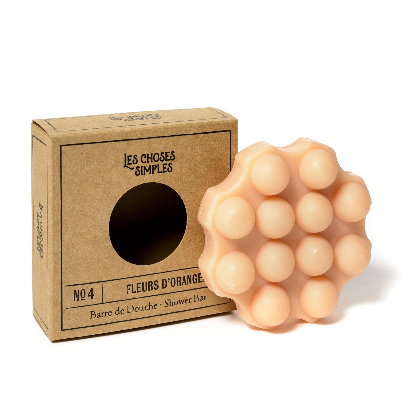 Shower Bar Les Choses Simples, savon solide hydratant à la fleur d'oranger, pour la douche, posé près de son emballage en carton