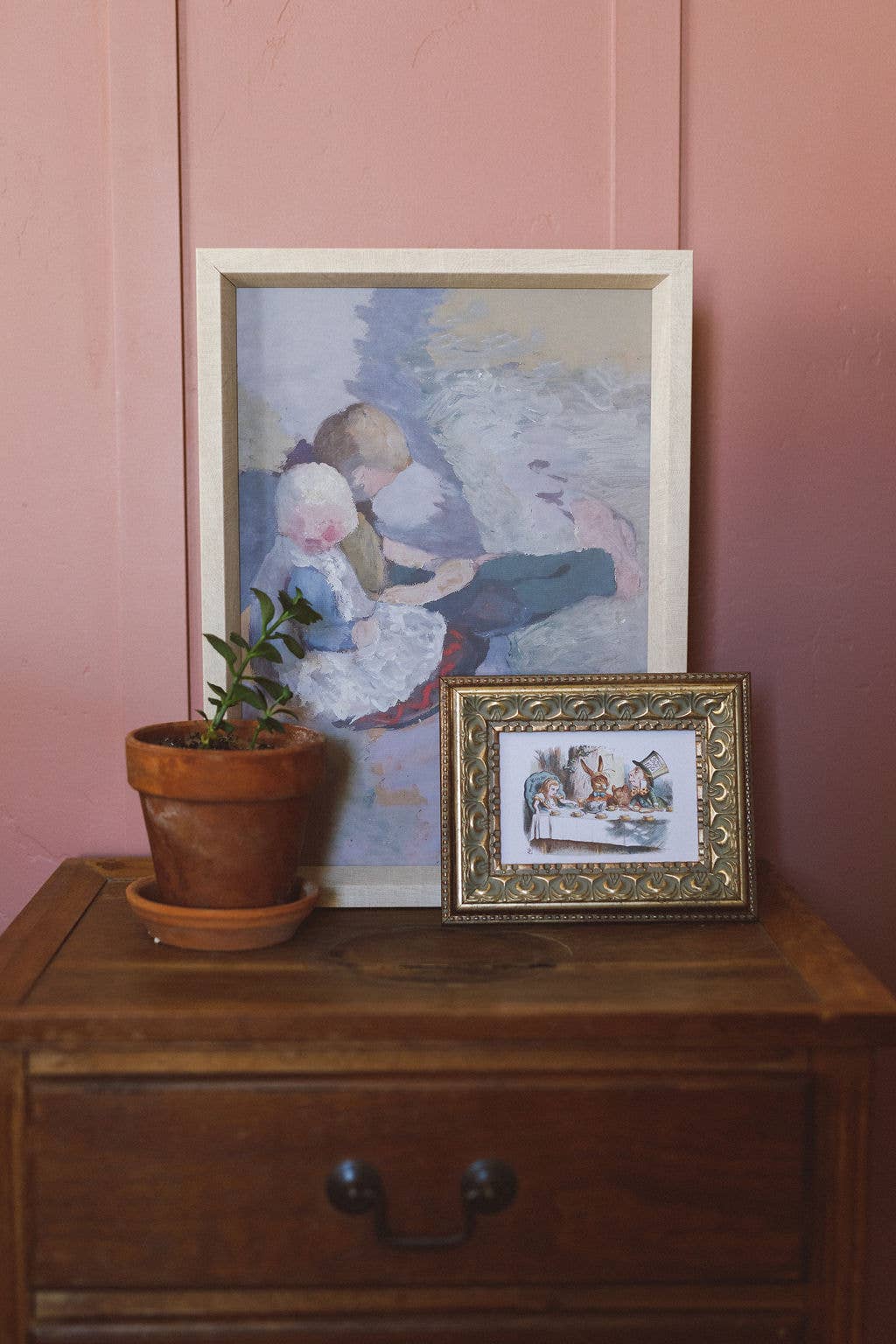 tableau d'enfants, oeuvre de Paula Modersohn-Becker (1902), posé sur une commode avec un mur couleur rose