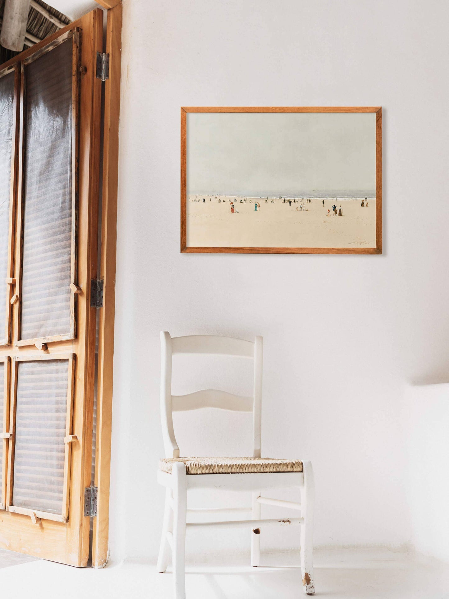 Affiche encadrée Plage au couchant exposée sur un mur lumineux au dessus d'une chaise blanche Madame Beaumont.