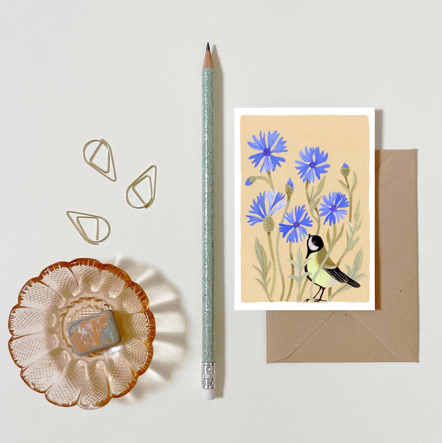 Carte illustrée représentant une mésange charbonnière parmi des bleuets dans un style botanique et champêtre.