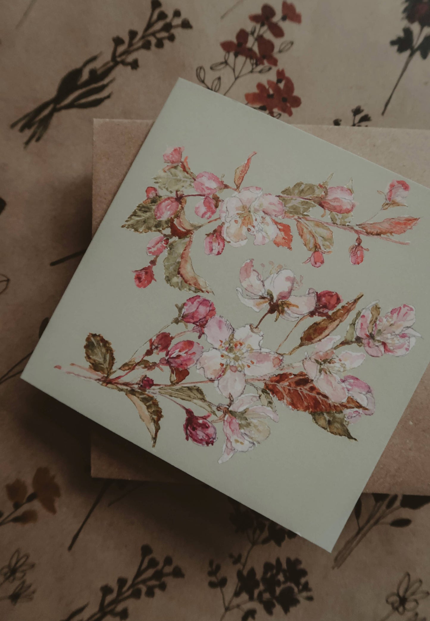 Carte de vœux pliée 13×13 cm avec illustration aquarelle de fleurs de prunier rose.