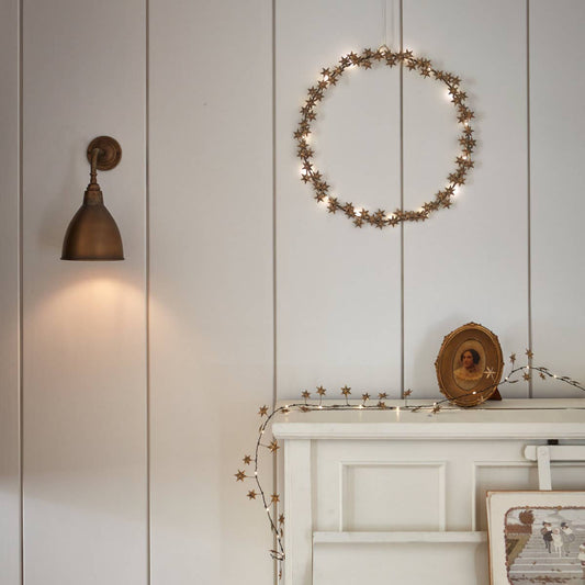 Couronne lumineuse dorée avec petites étoiles en métal et LED blanc chaud, décoration murale élégante Madame Beaumont.