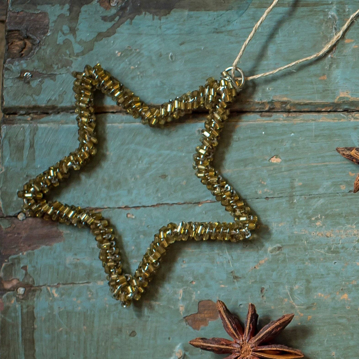 Étoile de Noël en perles de verre ancien avec cordon en jute naturel, disponible en deux tailles de 8 et 10 cm.