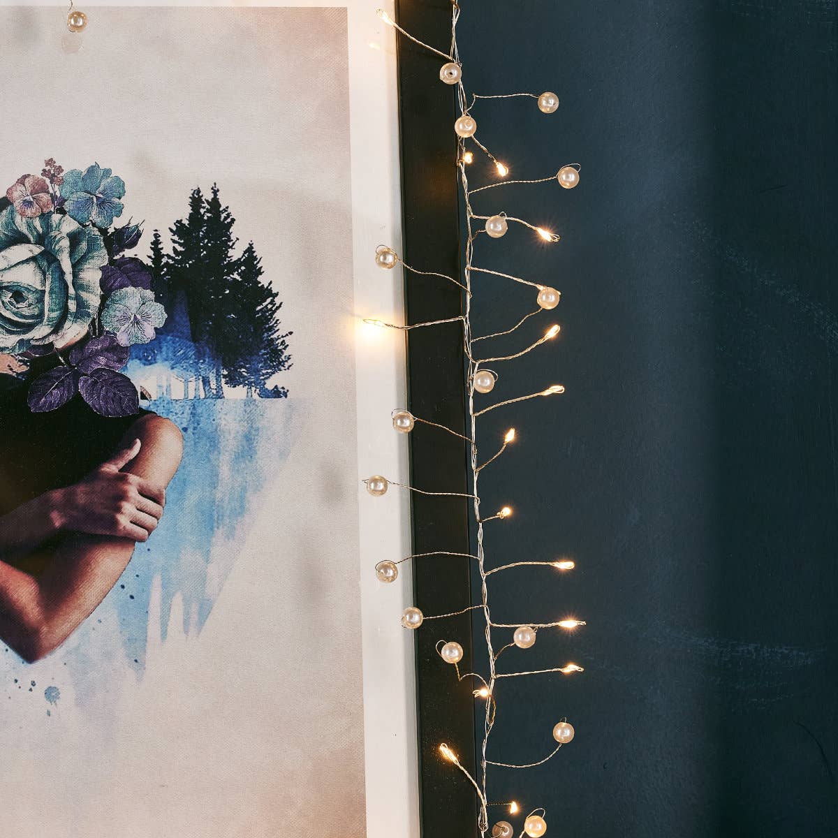 Guirlande perles nacrées suspendue sur miroir ancien, ambiance douce et élégante.