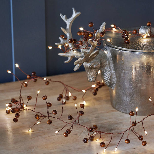 Guirlande lumineuse en baies de bois avec 100 LED blanc chaud, décoration de Noël naturelle et élégante.