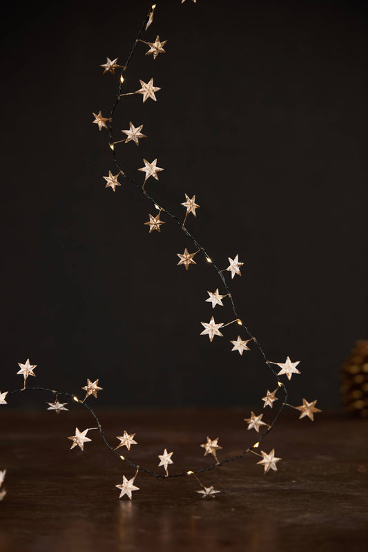 Guirlande lumineuse en métal doré avec étoiles et LED blanc chaud pour décoration de Noël.