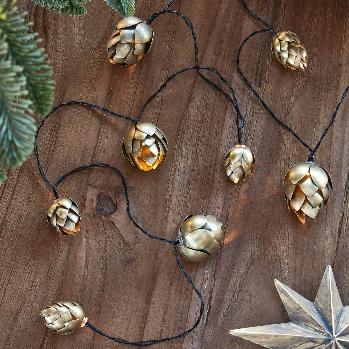 Guirlande lumineuse dorée en métal avec pommes de pin, décoration de Noël élégante Madame Beaumont.