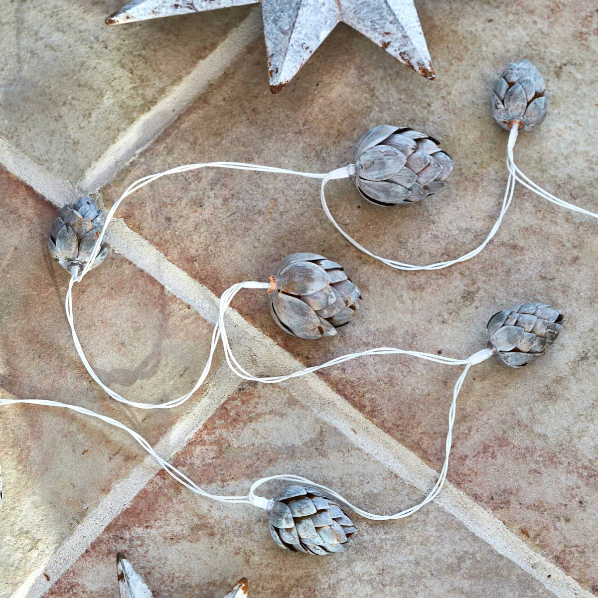 Décoration lumineuse de Noël en métal doré, pommes de pin et lumière douce pour intérieur.