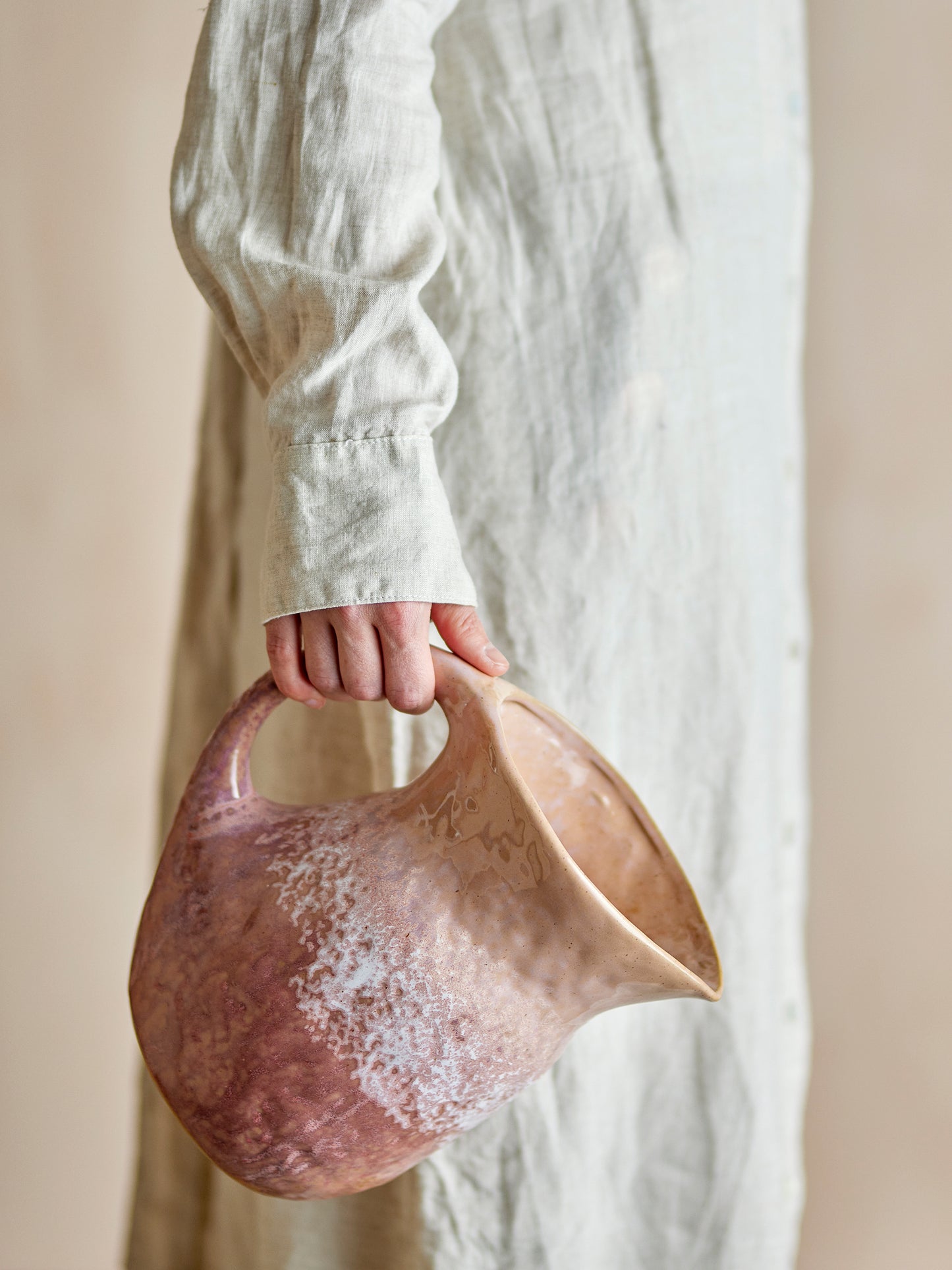Pichet Darlene en grès rose tenu à la main, mettant en valeur sa forme douce et sa finition artisanale.