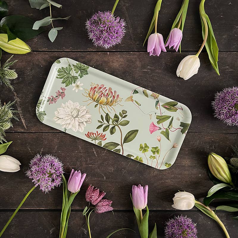 plateau ç fleurs couleur céladon, posé sur une table en bois et entouré de fleurs