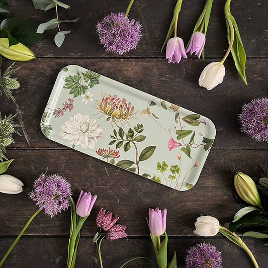 plateau ç fleurs couleur céladon, posé sur une table en bois et entouré de fleurs