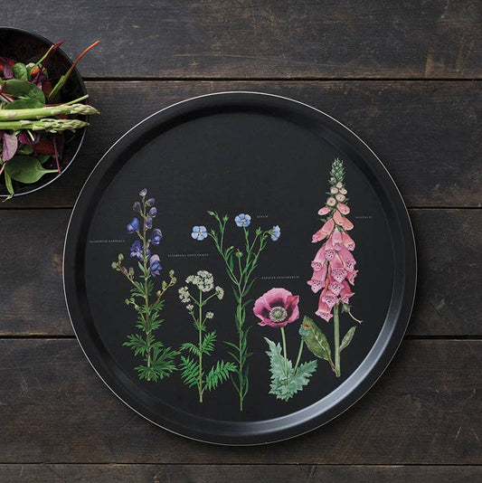 plateau rond noir avec des fleurs, posé sur une table en bois