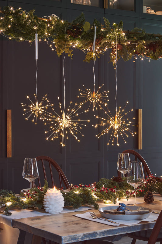 Suspension lumineuse dorée à LED suspendue au-dessus d’une table de fête – Collection Noël Madame Beaumont