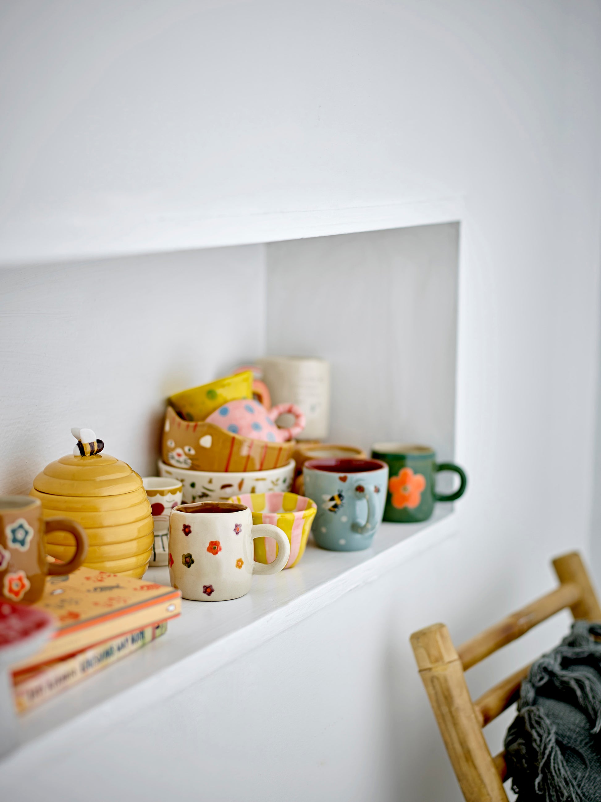 Tasse Addy fleurie Bloomingville MINI parmi une collection de vaisselle colorée dans une chambre d'enfant.