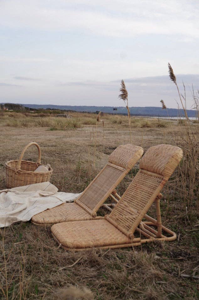 Chaise longue en rotin naturel en situation extérieure, accessoire chic pour jardin, plage ou pique-nique
